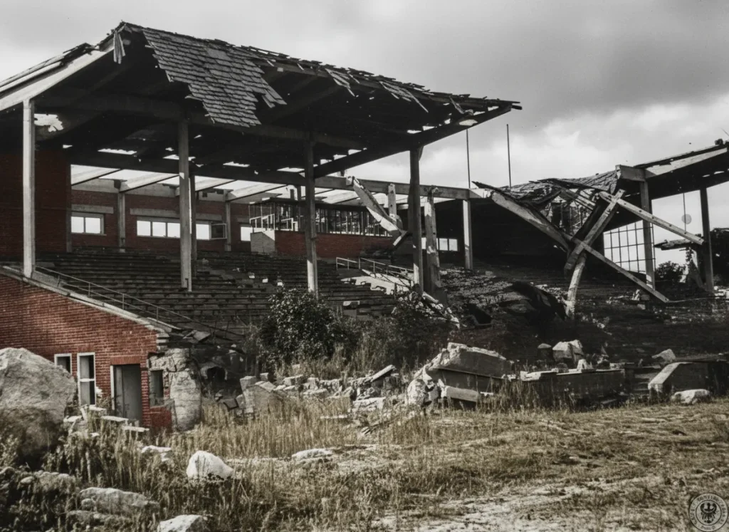 Zniszczona w wyniku działań wojennych Trybuna Główna Stadionu Olimpijskiego we Wrocławiu w 1945 roku, pokolorowana fotografia archiwalna.